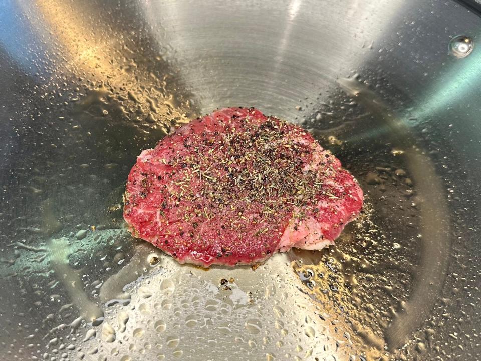 A piece of stake on a stovetop.