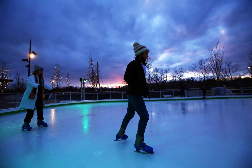 Karrer Middle School sixth-graders Elizabeth Black, 11, and Ella Gore, 11, take a spin around the ice rink in Riverside Crossing Park on Jan. 7. The rink opened Dec. 17 and will be open through mid-March.