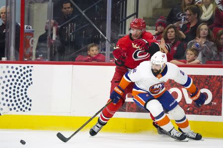 Nov 19, 2017; Raleigh, NC, USA; Carolina Hurricanes forward Jordan Staal (11) tries to get the puck away from New York Islanders defensemen Nick Leddy (2) during the second period at PNC Arena. James Guillory-USA TODAY Sports