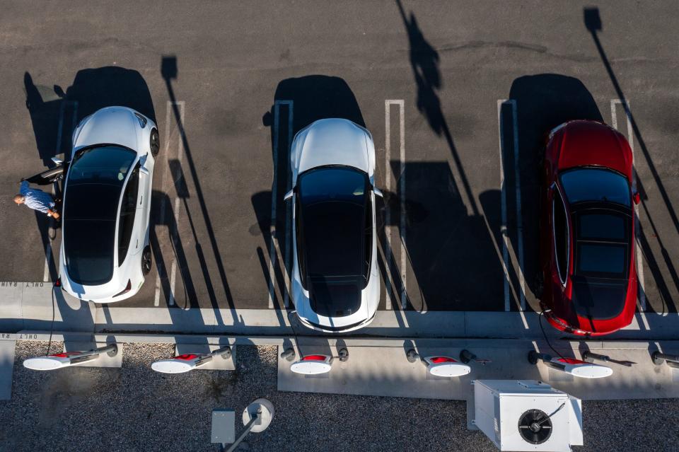 Tesla owners charge their vehicles at a Tesla Supercharger location at Indio Towne Center in Indio, Calif., on September 25, 2023.