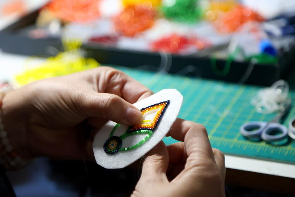 Molly Murphy Adams works on a beaded earring at her home studio in Tulsa, Okla., Sunday, March 3, 2024.