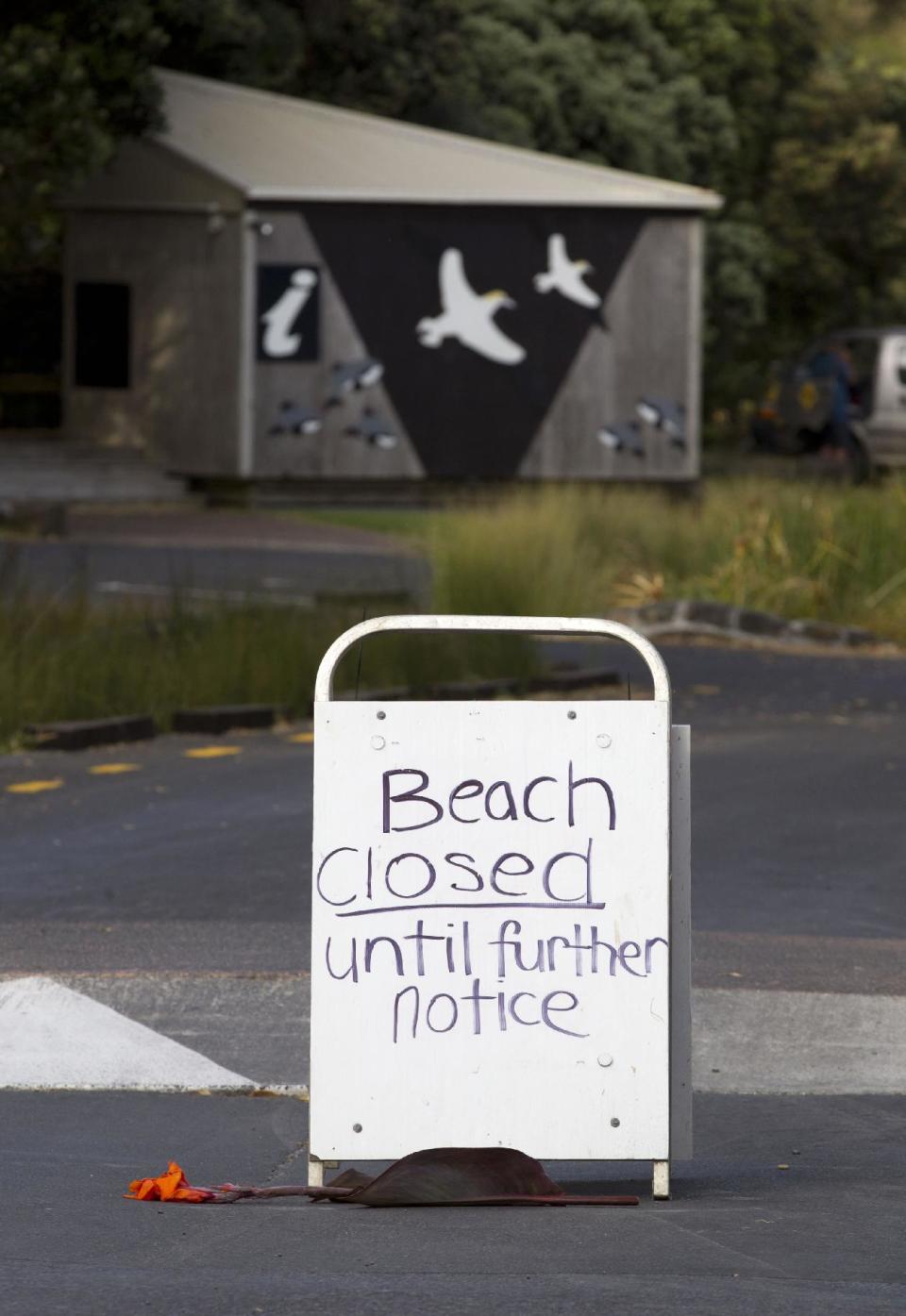 A "beach closed" sign is displayed at Muriwai Beach near Auckland, New Zealand, Thursday, Feb. 28, 2013, a day after Adam Strange was killed by a shark. About 150 friends and family of Strange, 46, wrote messages to him in the sand and stepped into the water Thursday at a New Zealand beach to say goodbye after he was killed Wednesday by a large shark. (AP Photo/New Zealand Herald, Brett Phibbs) New Zealand Out, Australia Out