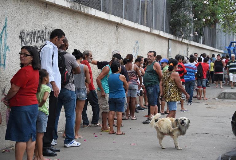 People queue at a polling station in Mare, a complex of favelas in Rio de Janeiro, Brazil, on October 26, 2014