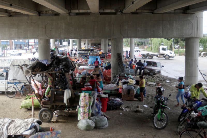 Una vista general muestra a las personas y sus pertenencias debajo de un puente, donde se refugian junto a otros residentes que perdieron sus viviendas debido a las inundaciones provocadas por las fuertes lluvias traídas por el huracán Iota, en San Pedro Sula, Honduras