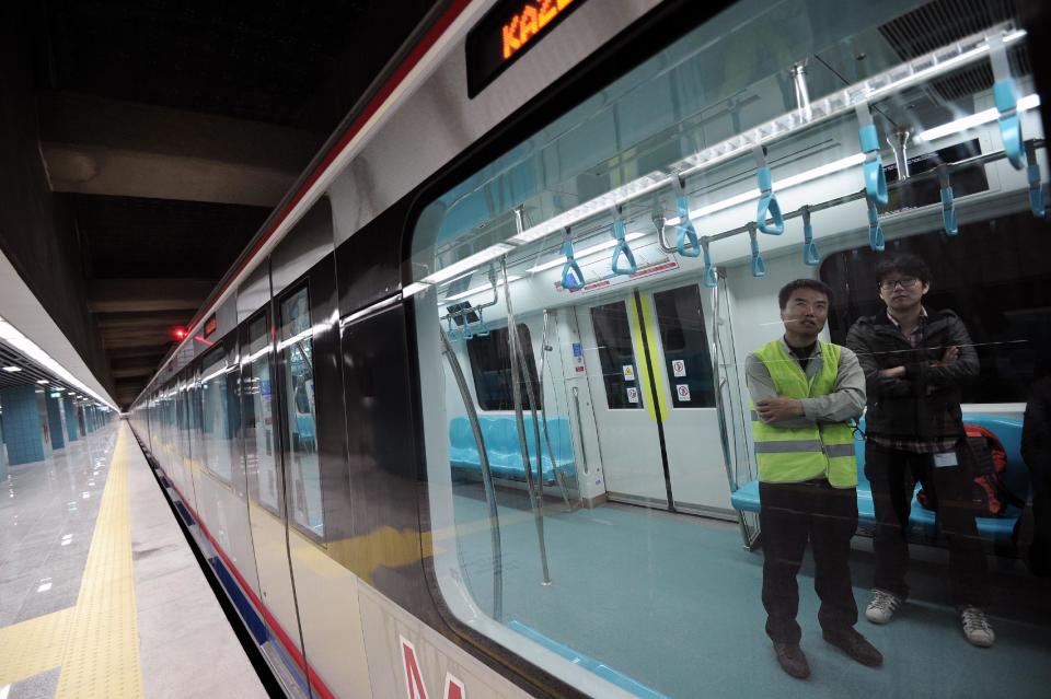 Two Japanese tecnicians wait inside a train for the inauguration of the tunnel called the Marmaray in Istanbul, Turkey, Tuesday, Oct. 29, 2013. Turkey is for the first time connecting its European and Asian sides with a railway tunnel set to open Tuesday, completing a plan initially proposed by an Ottoman sultan about 150 years ago. The Marmaray, is among a number of large infrastructure projects under the government of Prime Minister Recep Tayyip Erdogan that have helped boost the economy but also have provoked a backlash of public protest.(AP Photo)