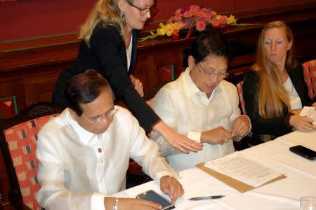 Philippine government negotiators Jesus Dureza (L) and Silvestre Bello sign an indefinite ceasefire agreement with communist rebels at a meeting in Oslo, Norway, August 26, 2016. REUTERS/Alister Doyle