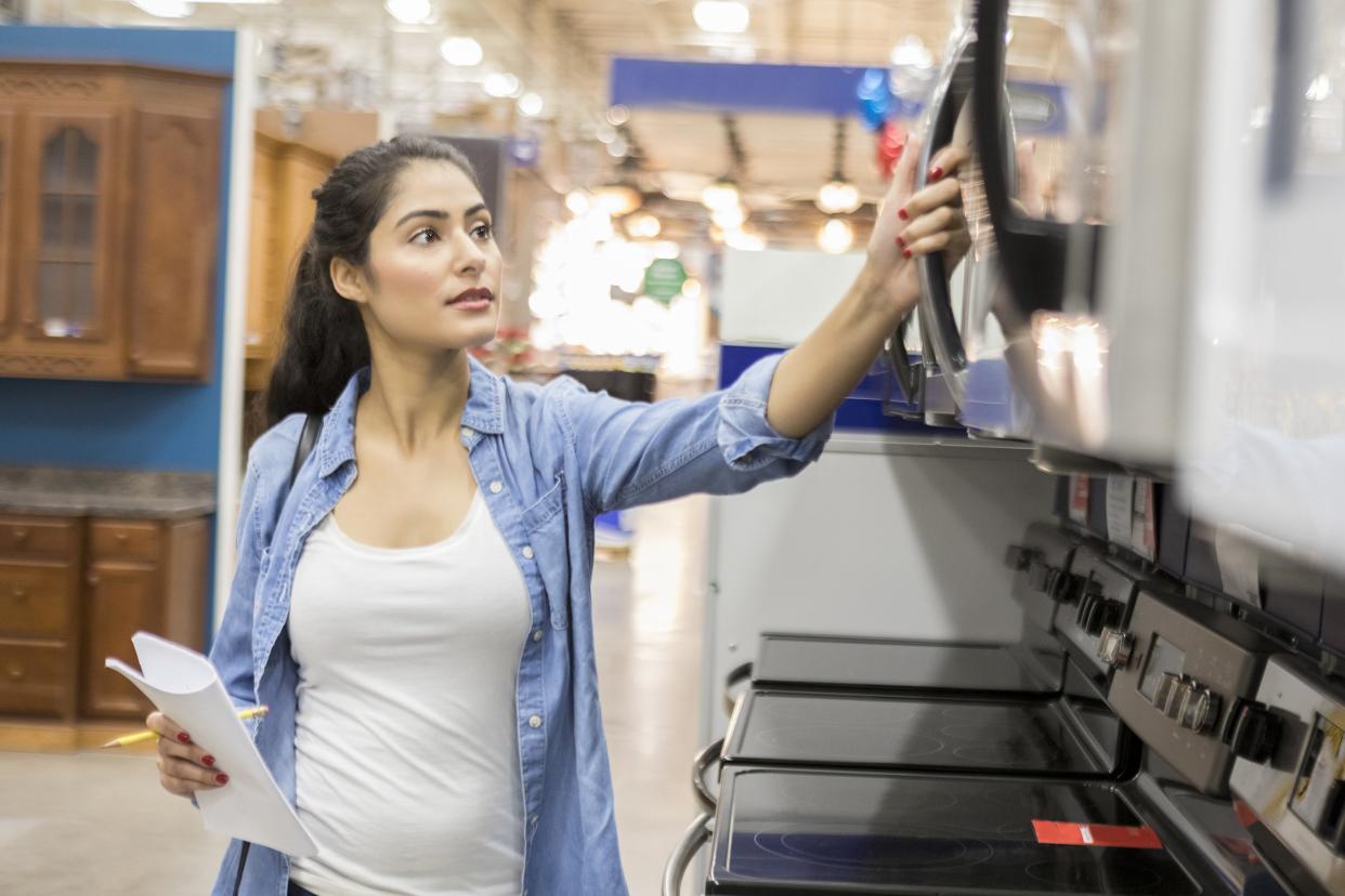 confident young woman shopping for microwave oven