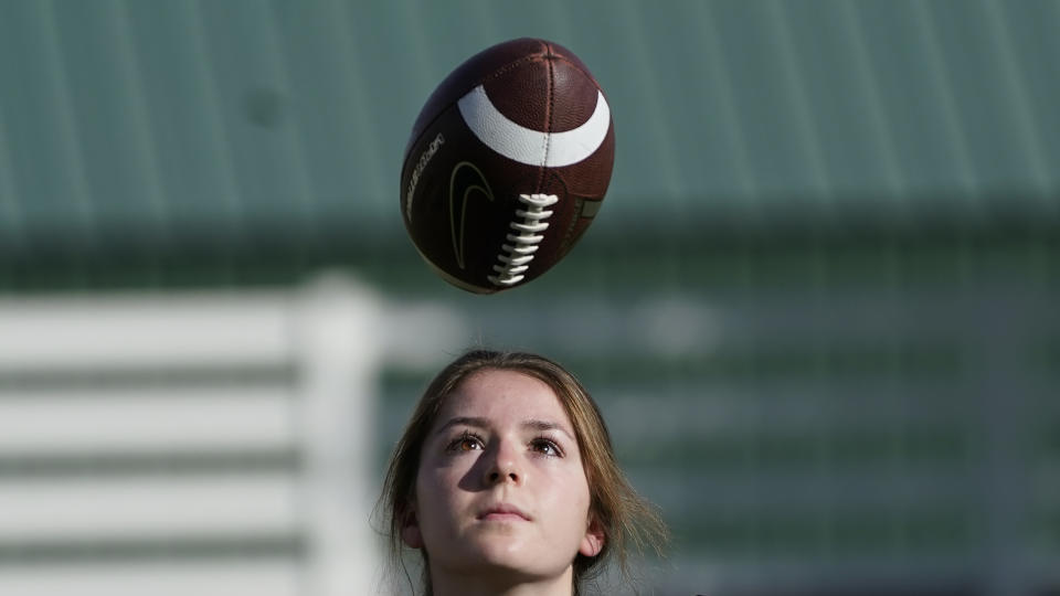 FILE - Sam Gordon looks at a football in Herriman, Utah, in this Oct. 20, 2020, file photo. A federal judge ruled against Gordon on Monday, March 1, 2021, finding that Utah school districts don't have to offer separate football teams for girls. (AP Photo/Rick Bowmer, File)