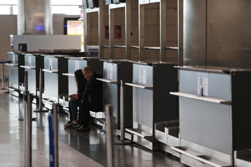 Passengers at Ataturk International Airport, in Istanbul, sit near the empty check-in counters, Friday, April 5, 2019, ahead of its closure. The relocation from Ataturk International Airport to Istanbul Airport on the Black Sea shores— dubbed the "Great Move"—began early Friday and is expected to end Saturday. Ataturk Airport, ranked 17th busiest in the world in 2018 according to preliminary statistics, will cease commercial operations at 02:00 am local Saturday (2300 GMT Friday.) (AP Photo/Lefteris Pitarakis)