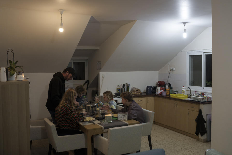 Raymond Reijnen and wife, Mirjam, share dinner with their children at the family’s temporary home in Yokne’am, northern Israel, Monday, February 5, 2024. (AP Photo/Leo Correa)
