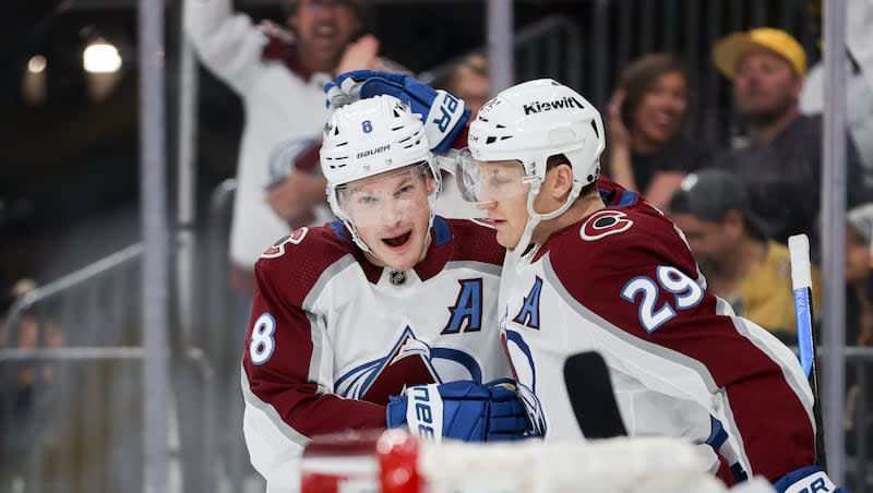 Colorado Avalanche defenseman Cale Makar (8) and center Nathan MacKinnon (29) celebrate after Makar's goal against the Vegas Golden Knights during an NHL hockey game, Sunday, April 14, 2024, in Las Vegas.