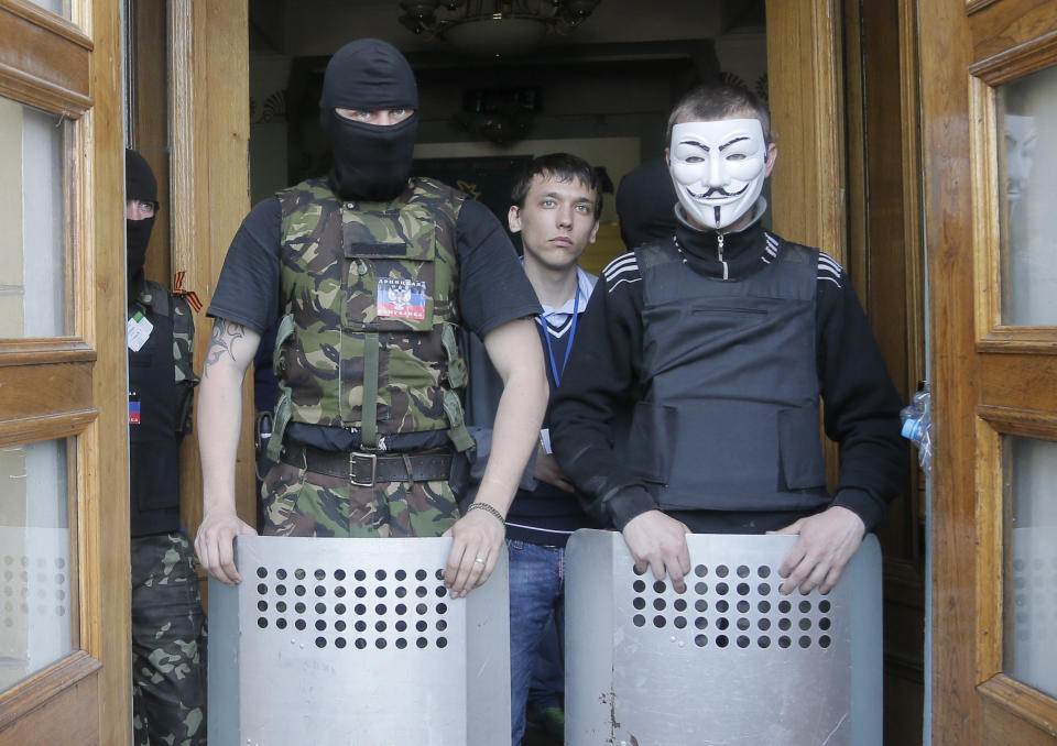 Masked pro-Russian activists guard the entrance during their mass storming of a regional Television Centre in Donetsk, Ukraine, Sunday, April 27, 2014. Insurgents in Slovyansk have taken a number of people hostage, including journalists and pro-Ukraine activists, as they strengthen their control in the east of the country in defiance of the interim government in Kiev and its Western supporters. (AP Photo/Efrem Lukatsky)