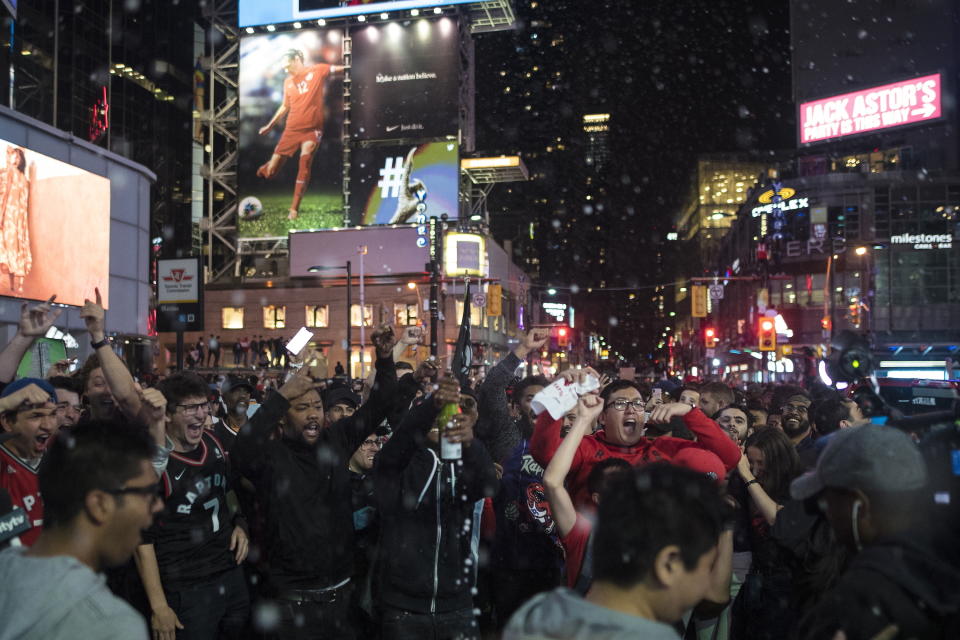 Fans celebrate with champagne as thousands of Toronto Raptors supporters flood the streets in celebration after the Raptors defeated the Golden State Warriors during Game 6 NBA Finals to win the NBA Championship, in Toronto on Friday, June 14, 2019. (Tijana Martin/The Canadian Press via AP)