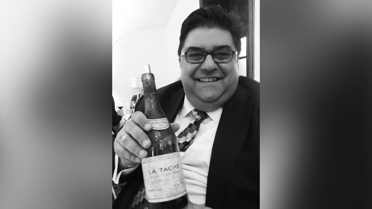 Omar Khan holding a bottle of wine