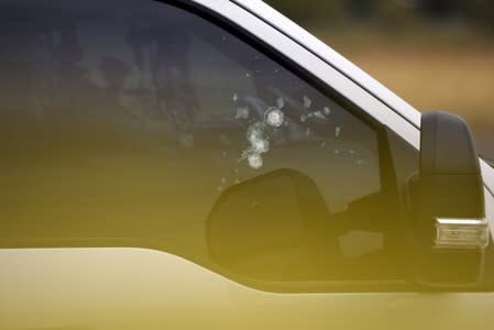 Bullet holes are seen in a car window near an Olive Garden following a shooting in Odessa