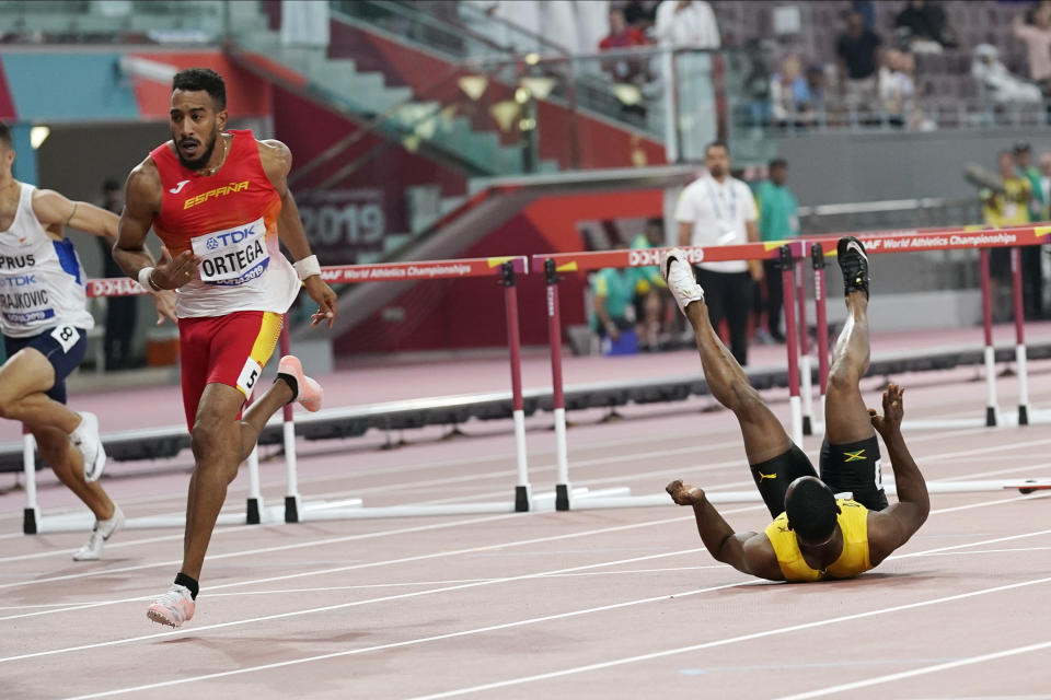 Omar Mcleod, of Jamaica, right, falls as Orlando Ortega, of Spain, finishes the the men's 110 meter hurdles final during the World Athletics Championships in Doha, Qatar, Wednesday, Oct. 2, 2019. (AP Photo/David J. Phillip)