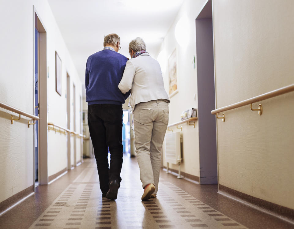 Senior couple walking a corridor in a senior home