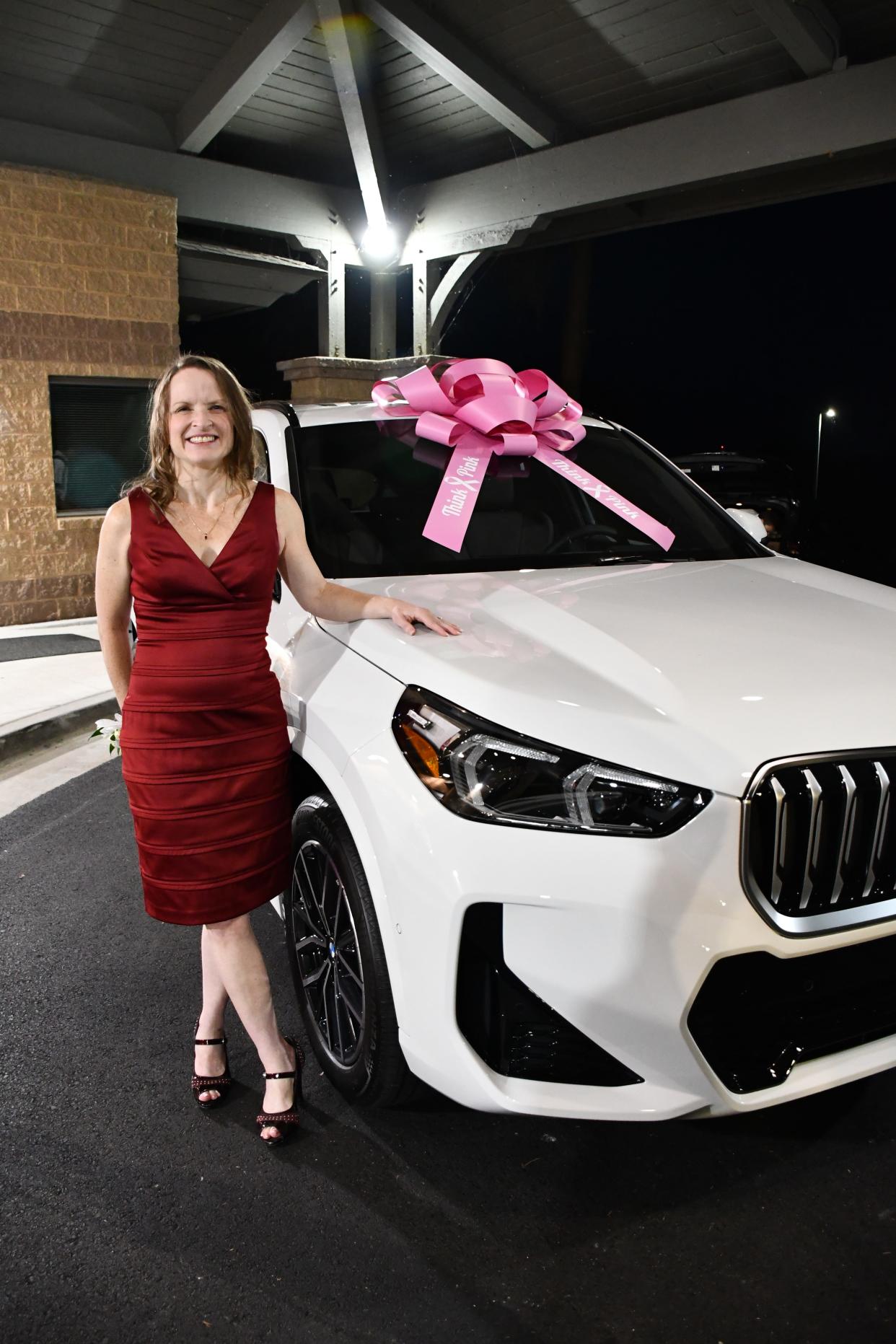 Crystal McDowell of Greenbrier High School stands in front of the new BMW X1 series SUV she won after being named Columbia County Teacher of the Year at Savannah Rapids Pavilion in Martinez on Wednesday, Oct. 4, 2023.