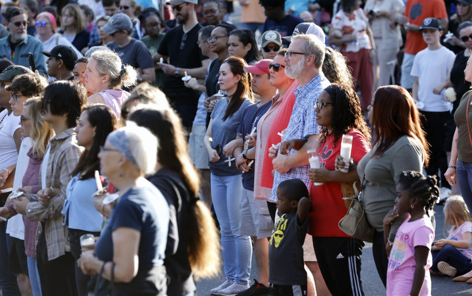 Attendees lock arms together in unity during a candlelight vigil, Saturday, Oct. 15, 2022, for those killed and wounded in a mass shooting in the Hedingham neighborhood in Raleigh, N.C., days earlier. (Ethan Hyman/The News & Observer via AP)