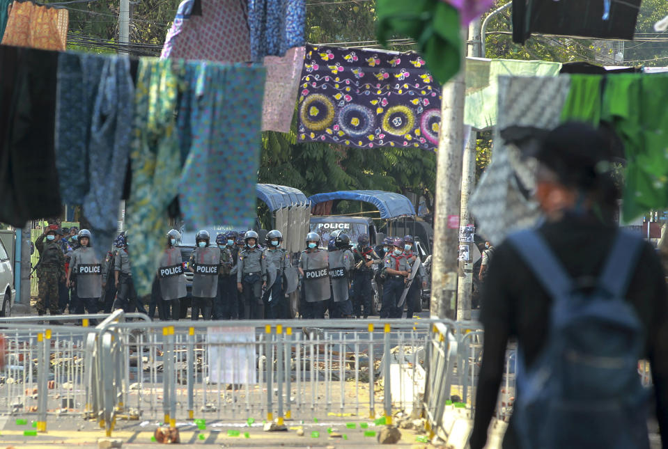 Anti-coup protesters stand behind a line of women's clothing hanged across a road to deter security personnel from entering the protest area in Yangon, Myanmar Tuesday, March 9, 2021. In Burmese culture, walking underneath women's clothing is believed to weaken the power of men and bring bad fortune. (AP Photo)