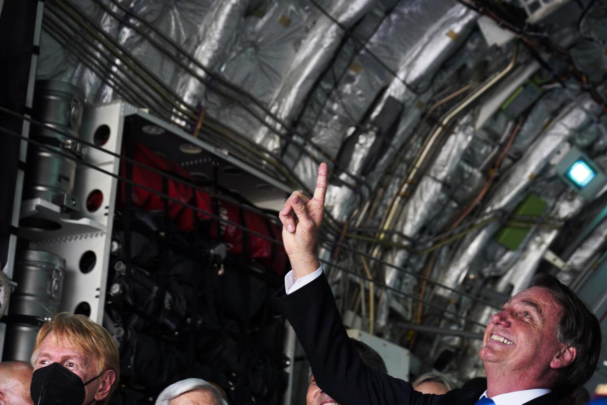 Brazilian President Jair Bolsonaro gestures inside of a Brazilian Air Force Embraer KC-390 at the Dubai Air Show in Dubai, United Arab Emirates, Sunday, Nov. 14, 2021. The biennial Dubai Air Show opened Sunday as commercial aviation tries to shake off the coronavirus pandemic. (AP Photo/Jon Gambrell)