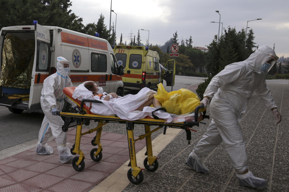 Medical personnel transfer a COVID-19 patient from a state to a private clinic which has been appropriated, in the northern city of Thessaloniki, Greece, Sunday, Nov. 29, 2020. Greece's Health ministry has forcibly appropriated two clinics and their staff in the country's second populated city, where the outbreak is the most severe. (AP Photo/Achilleas Chiras)