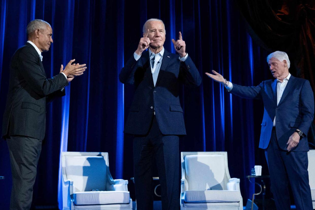 <p>BRENDAN SMIALOWSKI/AFP via Getty</p> President Joe Biden (center) with former Presidents Barack Obama (left) and Bill Clinton (right)