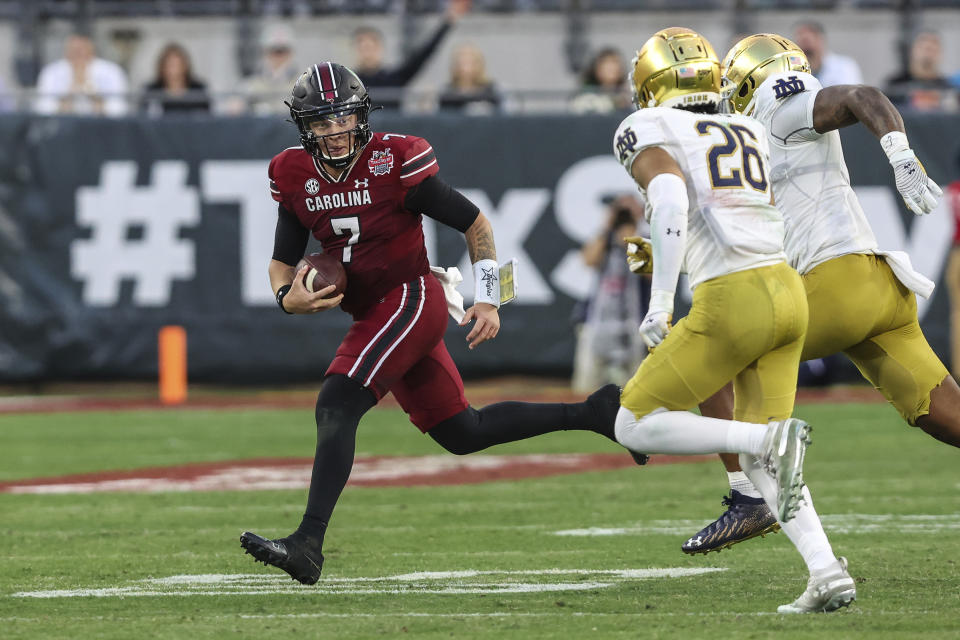 South Carolina quarterback Spencer Rattler (7) scrambles during the second quarter of the Gator Bowl NCAA college football game against Notre Dame on Friday, Dec. 30, 2022, in Jacksonville, Fla. (AP Photo/Gary McCullough)