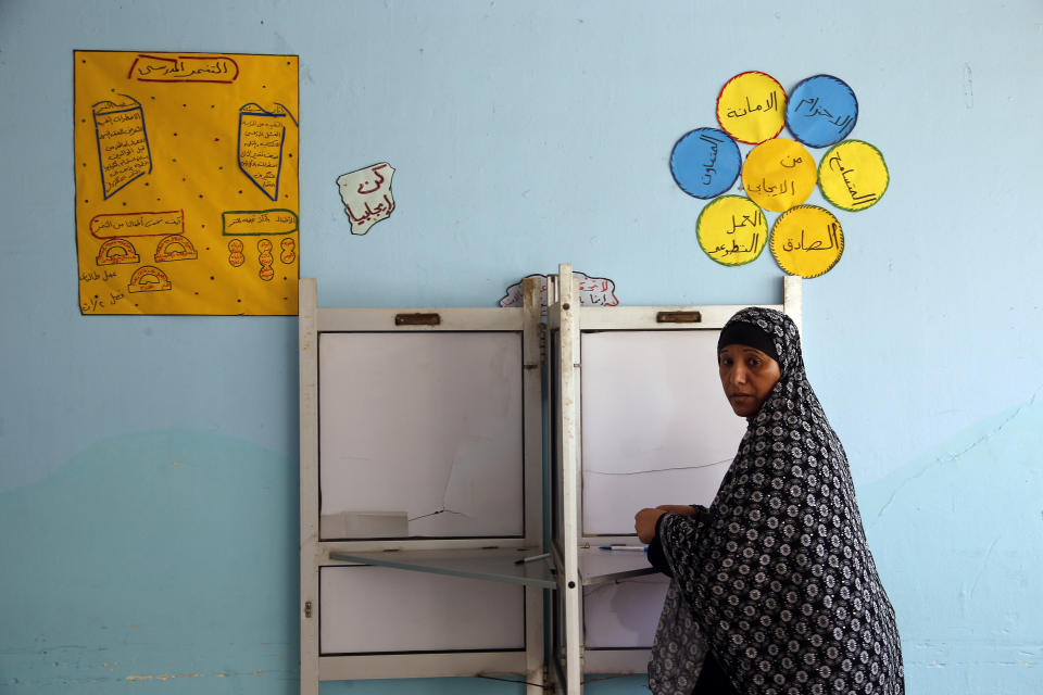 A voter prepares to cast her ballot on constitutional amendments during the second day of three-day voting at polling station in Cairo, Egypt, Sunday, April 21, 2019. Egyptians are voting on constitutional amendments that would allow President Abdel-Fattah el-Sissi to stay in power until 2030. (AP Photo/Amr Nabil)