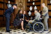 Britain's Prince William and the Duchess of Cambridge speak with wounded soldiers as they visit the military hospital at the Hotel des Invalides in Paris, on March 18, 2017