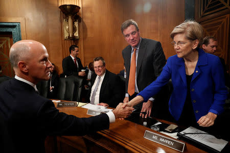 Richard Smith, former chairman and CEO of Equifax, Inc., greets Sen. Elizabeth Warren (D-MA) prior to testifying before the U.S. Senate Banking Committee on Capitol Hill in Washington, U.S., October 4, 2017. REUTERS/Aaron P. Bernstein