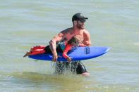 Chris went into super dad mode as he took his four-year-old daughter India out for a surfing lesson. The doting father showed off his bulging muscles, while India looked so excited to be catching waves!