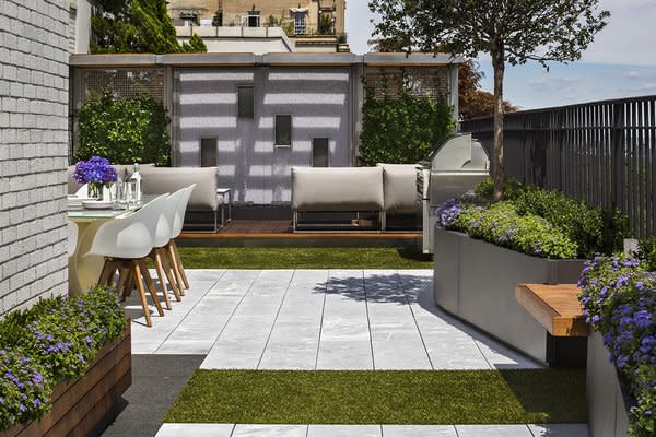 Limestone pavers and easy-to-maintain AstroTurf recreate the feel of a country patio underfoot, right in one of the busiest cities in the world.