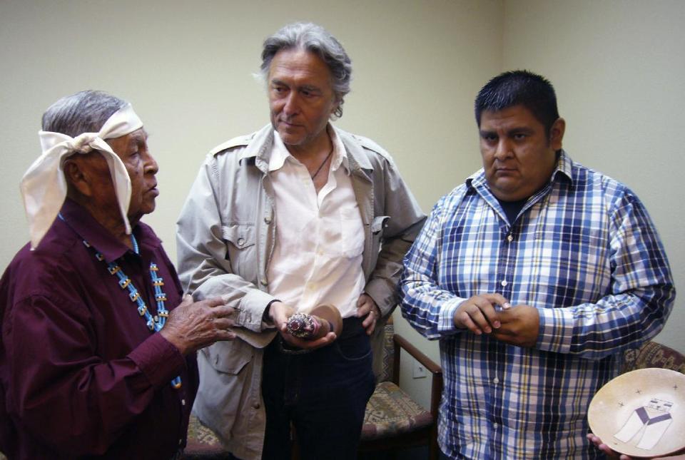 This July 2013 photo released courtesy of Survival International shows Hopi tribal elder Lawrence Keevama, left, speaking with French attorney, Pierre Servan-Schreiber, center, and Sam Tenakhongva, Hopi Kachina Society leader, at the Hopi tribal offices in Flagstaff, Ariz. Servan-Schreiber twice sought to block the sale of Hopi ceremonial items from auction in France, working on behalf of the Hopi Tribe and Survival International. (AP Photo/Survival International)