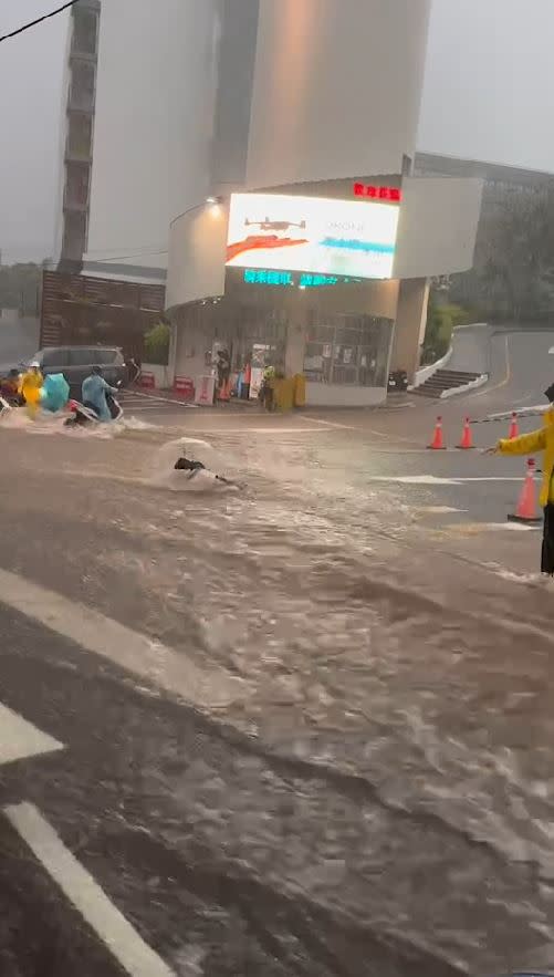 暴雨襲擊台中，弘光科大學生冒險涉水而過，女學生站不穩差點被湍急洪水沖走。(圖／翻攝自記者爆料網)