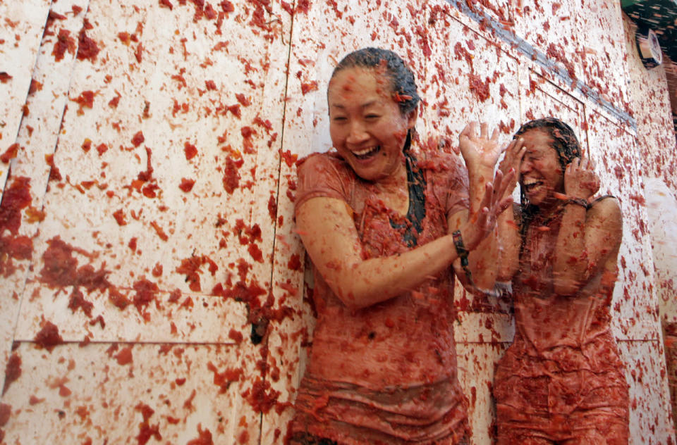 <p>Two women enjoy as crowds of people throw tomatoes at each other, during the annual “Tomatina”, tomato fight fiesta, in the village of Bunol, 50 kilometers outside Valencia, Spain, Aug. 31, 2016. (Photo: Alberto Saiz/AP)</p>