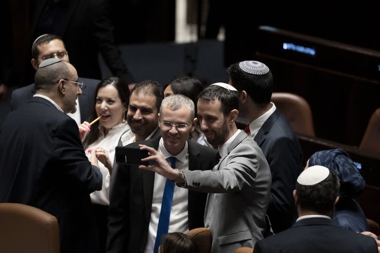 Un legislador israelí se toma un selfie con el Ministro de Justicia Yariv Levin después de que aprobaron una parte clave del polémico plan del primer ministro Benjamin Netanyahu para remodelar el sistema judicial del país, el lunes 24 de julio de 2023. 