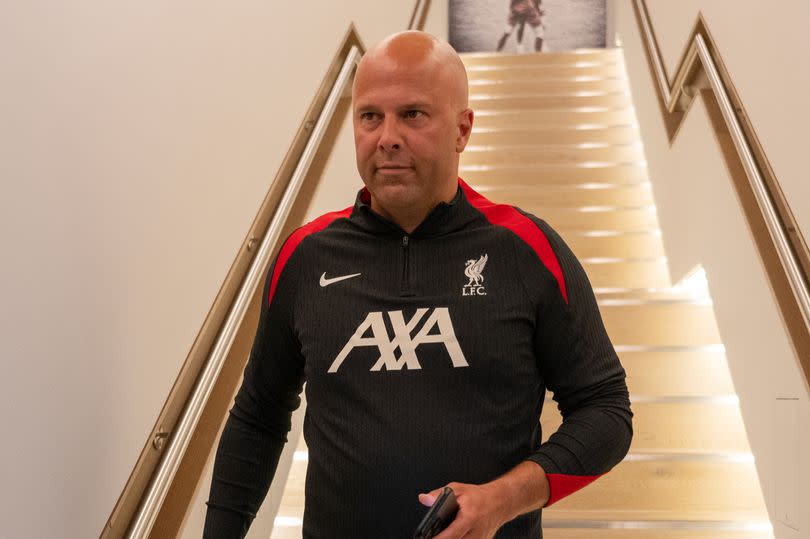 Arne Slot walks down some stairs at Liverpool's AXA Training Centre.