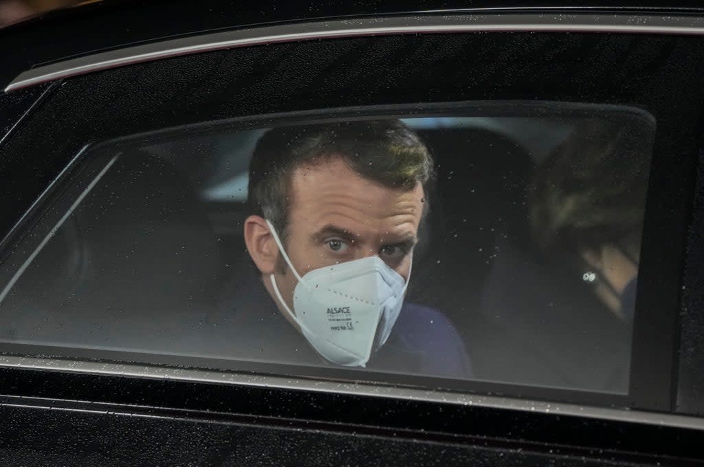 French President Emmanuel Macron looks out of her car window as he arrives for a meeting with German Chancellor Olaf Scholz at the chancellery in Berlin (AP)