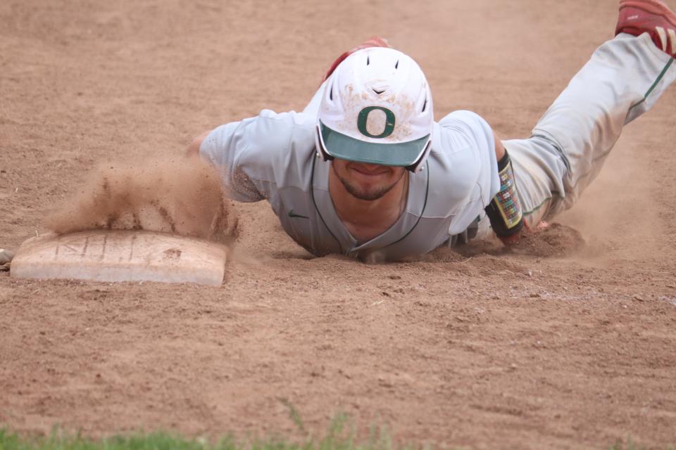 Oak Harbor's Brayden Butzin dives back to first base.