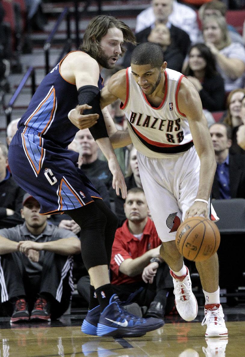 Portland Trail Blazers forward Nicolas Batum, right, from France, drives on Charlotte Bobcats forward Josh McRoberts during the first half of an NBA basketball game in Portland, Ore., Thursday, Jan. 2, 2014. (AP Photo/Don Ryan)