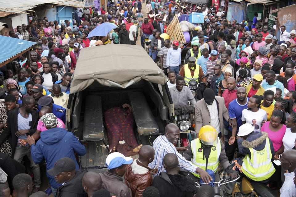 Residents gather around the covered dead body of a woman retrieved from a house, after heavy rain in the Mathare slum of Nairobi, Kenya, Wednesday, Apr. 24, 2024. Heavy rains pounding different parts of Kenya have led to dozens of deaths and the displacement of tens of thousands of people, according to the U.N., citing the Red Cross. (AP Photo/Brian Inganga)