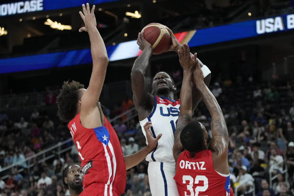 United States' Anthony Edwards, center, shoots over Puerto Rico's George Conditt IV, left, and Christopher Ortiz, right, during the first half of an exhibition basketball game Monday, Aug. 7, 2023, in Las Vegas. (AP Photo/John Locher)