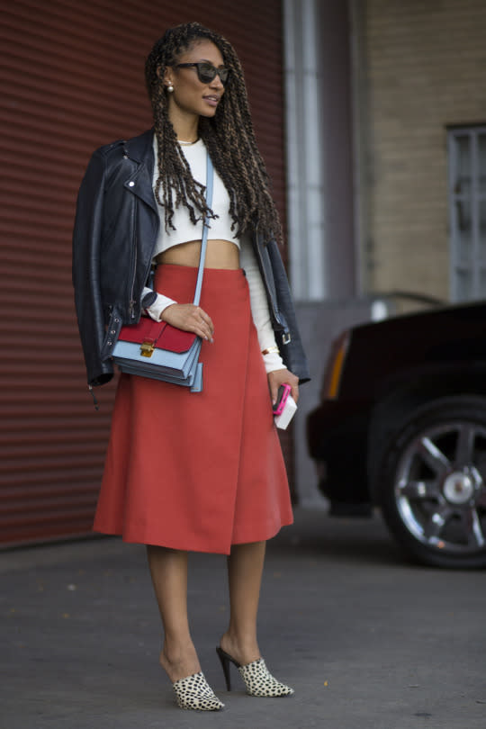 <p>When in doubt—drape a leather jacket over your shoulders. She decided to pair hers with a red wrap skirt, white crop top and two-tone purse. </p>