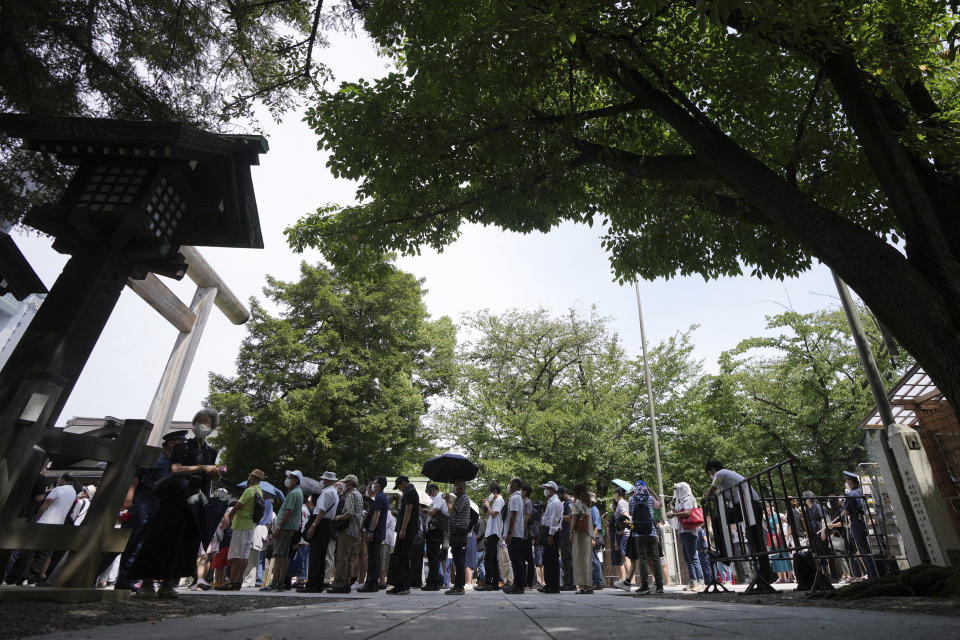 People queue to pay respects to the war dead at Yasukuni Shrine Monday, Aug. 15, 2022, in Tokyo. Japan marked the 77th anniversary of its World War II defeat Monday. (AP Photo/Eugene Hoshiko)