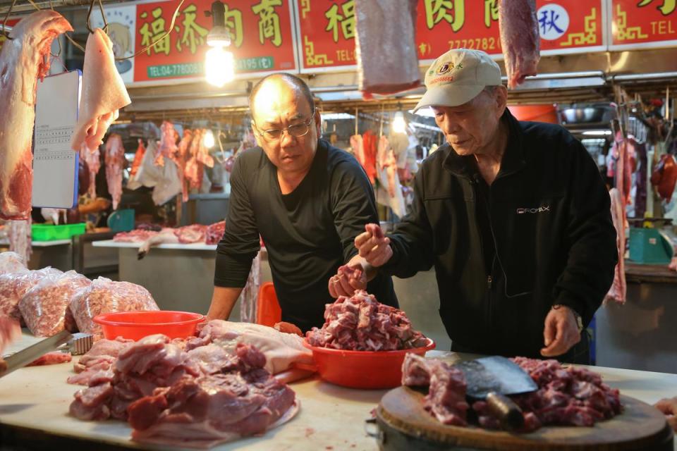 為掌握食材品質，施世揚(右)與施明裕(左)堅持只向有信譽的肉攤採購溫體現宰豬肉。