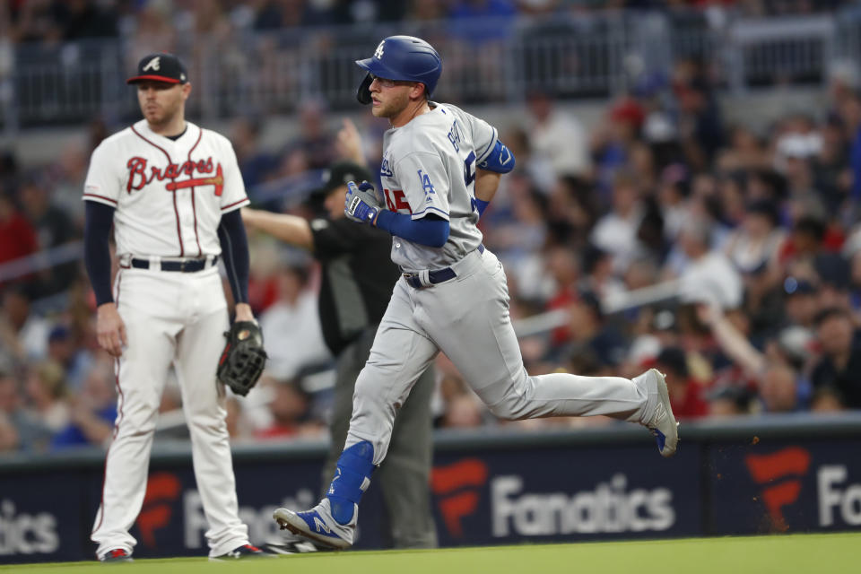 Los Angeles Dodgers' Matt Beaty (45) runs past Atlanta Braves first baseman Freddie Freeman, left, after hitting a home run in the fourth inning of a baseball game Saturday, Aug. 17, 2019, in Atlanta. (AP Photo/John Bazemore)