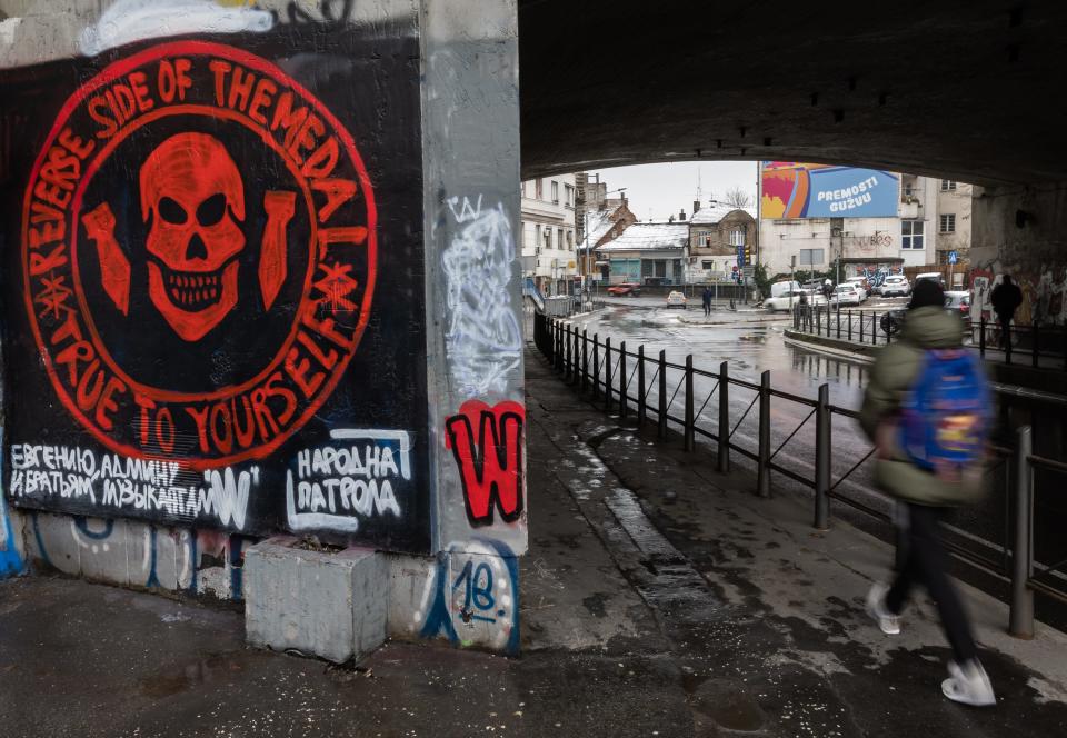 A pedestrian walks past a mural depicting the logo of the Russian mercenary 'Group Wagner' and a slogan in Russian on January 20, 2023 in Belgrade, Serbia.