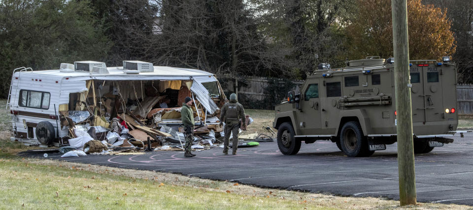 Police examine a stolen RV after ramming it multiple times with an armored vehicle, right, while searching for a Marine deserter who is wanted for questioning in a murder case, in Roanoke, Va. (AP Photo/Don Petersen)