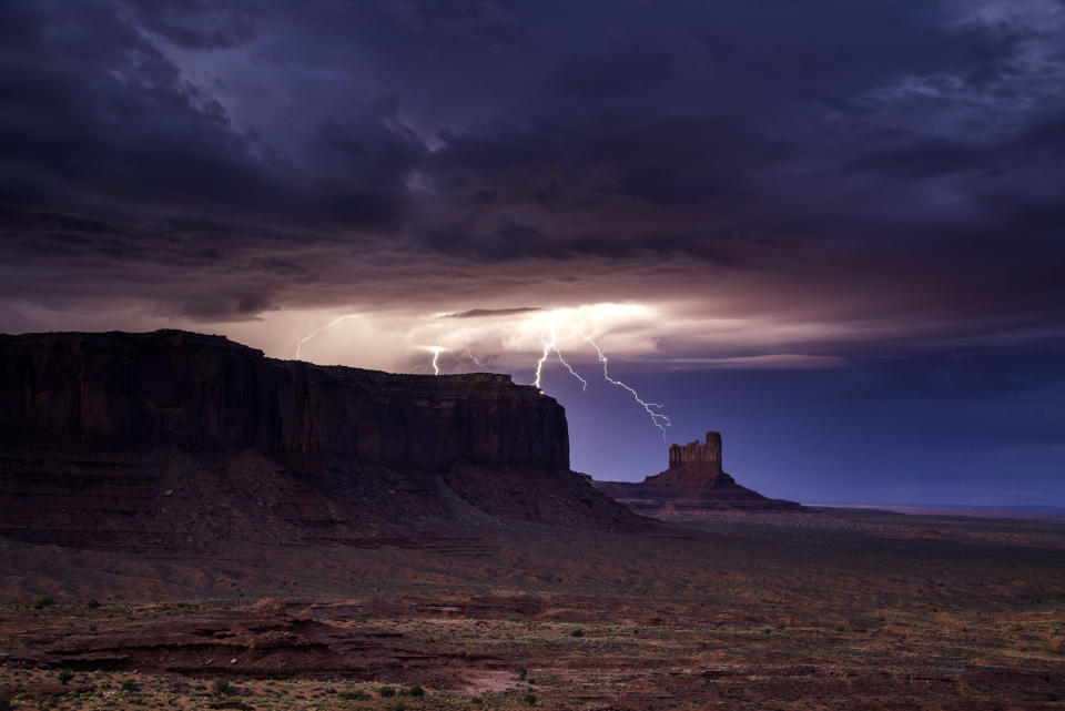 <p>Rain and lightning bolts hammer the desolate terrain of Monument Valley, Ariz. (Photo: Jennifer Khordi/Caters News) </p>